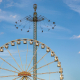 Ein Riesenrad steht vor einem Kettenkarussel.